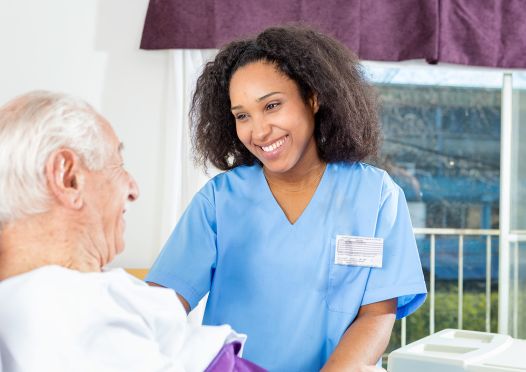 A caregiver warmly smiling at her patient. 